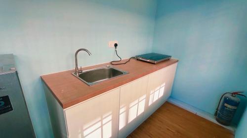 a kitchen counter with a sink in a room at Kulai Bandar Putra Self Service Hotel near IOI Mall in Kulai