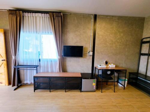 um quarto com uma cama, uma mesa e uma janela em ถึงเที่ยงวัลเลย์เขาใหญ่ em Ban Bung Toei