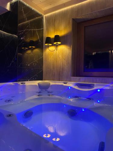 a large tub in a bathroom with blue lights at Little House in Ząb