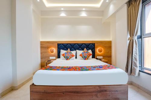 a bedroom with a large bed with a wooden headboard at FabHotel Pancharatna Regency in Pune