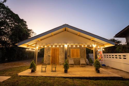 - un pavillon avec des chaises et des lumières dans l'arrière-cour dans l'établissement Tararom ธาราลม, 