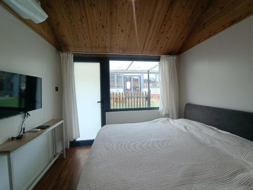 a bedroom with a bed and a large window at Kyoguro in Miyun