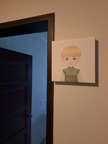 a picture of a boy on a wall next to a door at 如日民宿 in Taitung City