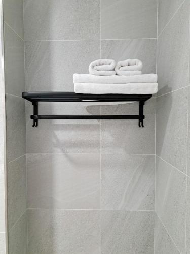a bathroom with three towels on a shelf at 如日民宿 in Taitung City