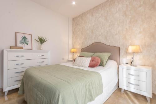 a bedroom with a bed and a dresser with two lamps at Osario Suite Centro Cordoba in Córdoba