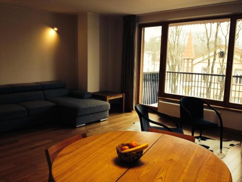 ein Wohnzimmer mit einem Tisch und einer Obstschale darauf in der Unterkunft Apartment in Druskininkai Lithuania in Druskininkai