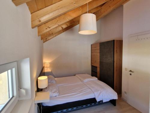 a bedroom with a bed and a wooden ceiling at Lovely holiday home within walking distance of the ski slope and a subtropical swimming pool in Kötschach