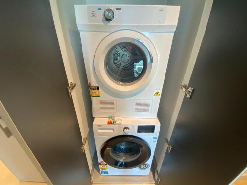 a washer and dryer in a room at Paragon Apartments by CLLIX in Melbourne