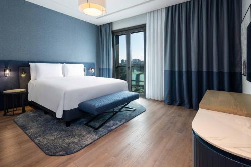 a hotel room with a bed and a window at Movenpick Living Istanbul Camlivadi in Istanbul