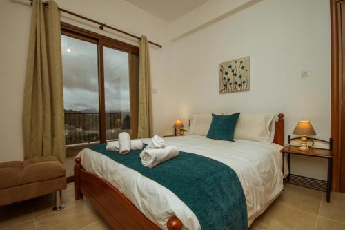 een slaapkamer met een bed met handdoeken erop bij Villa Callisto by AgroHolidays in Kyperounda