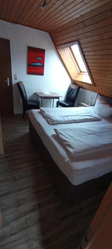 a bedroom with a bed and a table and chairs at Pension Grübel in Lindau