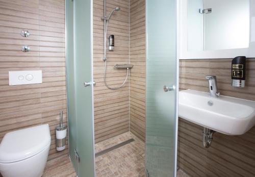 a bathroom with a toilet and a sink at CityHotel am McKeePlatz in Crailsheim