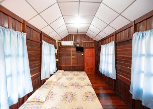 um quarto vazio com uma cama num quarto com cortinas em Baan Pak Wangthong em Ban Dung