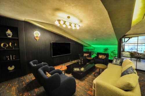 a living room with two couches and a tv at The Alpfine Hotel in Ankara