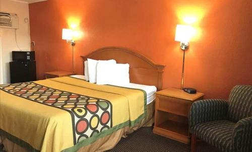 a hotel room with a large bed and a chair at Happy Stay Inn in Hannibal