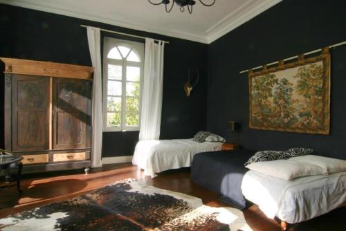 a living room with two beds and a window at Villa Pradias in Loures-Barousse