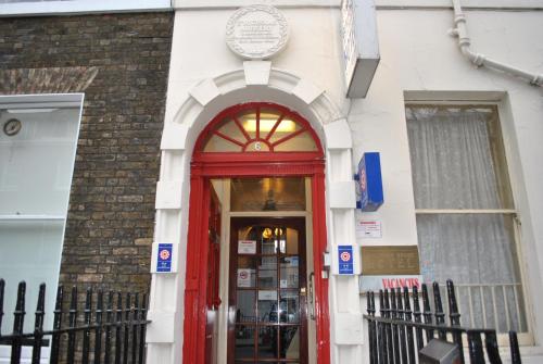 a red door into a building with a sign above it at Guilford House Hotel in London