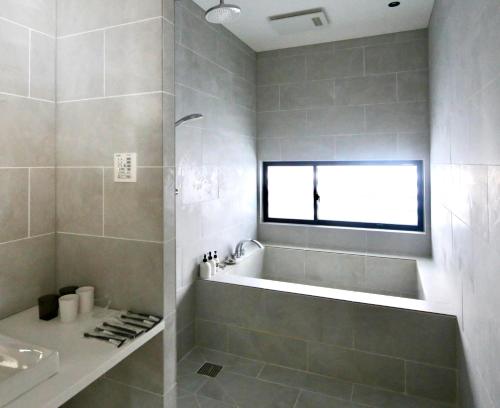 uma casa de banho com uma banheira e um lavatório em Niseko Bisha 美舎 Onsen Villas em Niseko