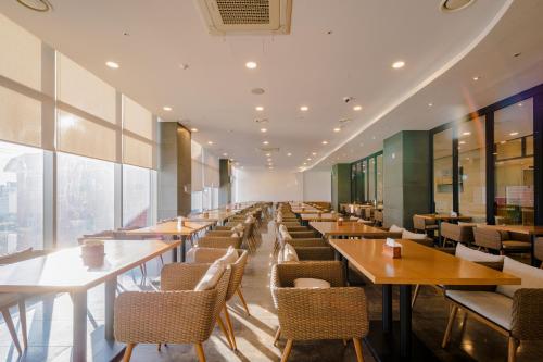 a long row of tables and chairs in a restaurant at Hotel bridge Seogwipo in Seogwipo