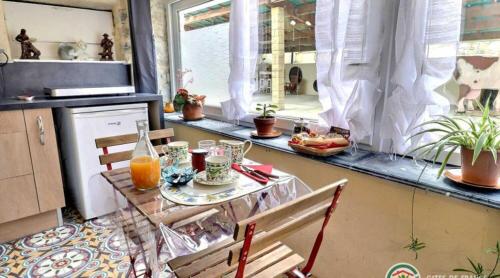 a kitchen with a table with drinks and fruits on it at Le cocon in Rochecolombe