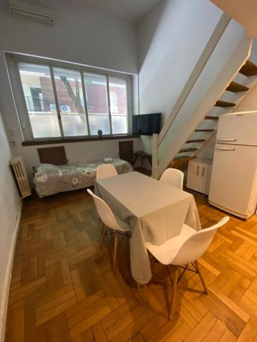um quarto com uma mesa e cadeiras e uma escada em Downtown Apartament Retiro em Buenos Aires