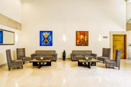a lobby with couches and tables and paintings at Lemon Tree Hotel Electronics City in Bangalore