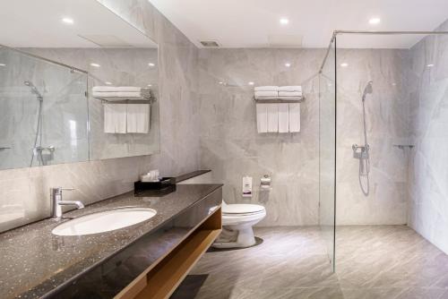 y baño con aseo, lavabo y ducha. en Mike Garden Resort - SHA EXTAR PLUS, en Pattaya central