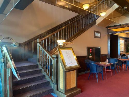 a staircase in a restaurant with a table and chairs at Wellness Forest Nasu in Nasu