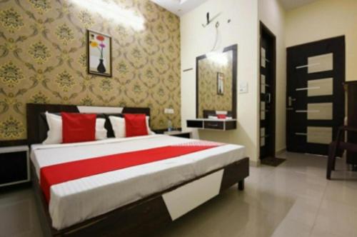 um quarto com uma cama grande e almofadas vermelhas em Hotel Broadway By WB Inn em Amritsar