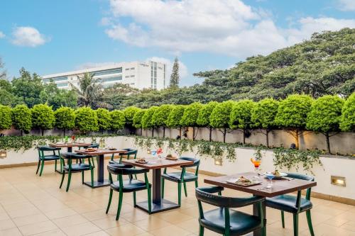 a row of tables and chairs on a patio at Lemon Tree Hotel Electronics City in Bengaluru