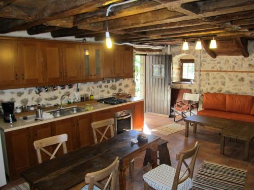 a kitchen and living room with a wooden table and a tableablish at Guesthouse Ventista-Ξενώνας in Theodoriana