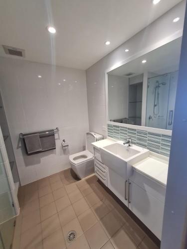 a bathroom with two sinks and a toilet and a mirror at Cue Motel in Cue