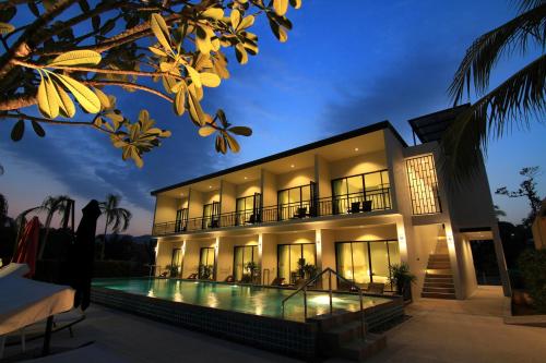 a villa with a swimming pool at night at The Fusion Resort Hotel in Chalong