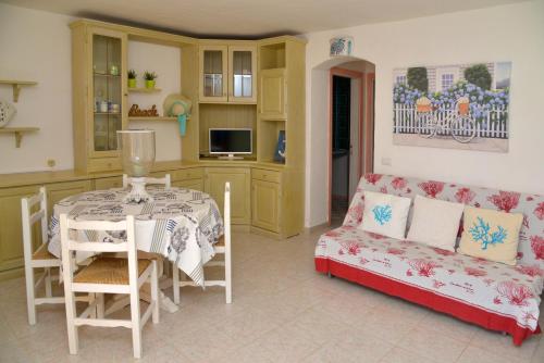 uma sala de estar com uma mesa e um sofá em Casa UGB em Cannigione