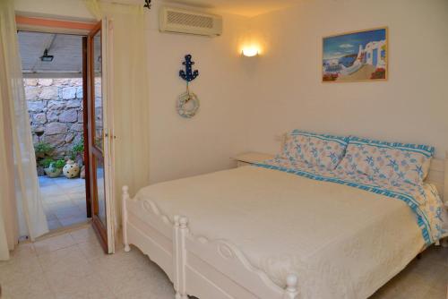 a bedroom with a white bed with blue pillows at Casa UGB in Cannigione