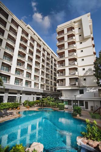 a swimming pool in front of two large buildings at Mike Garden Resort - SHA EXTAR PLUS in Pattaya
