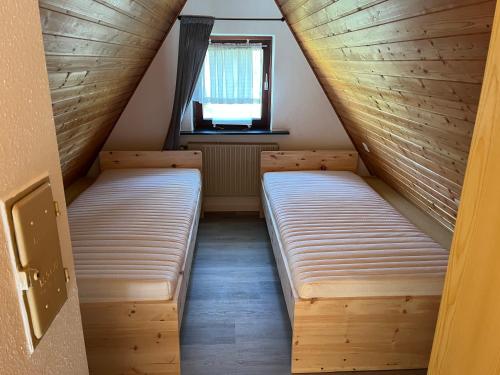 2 camas en una habitación pequeña con ventana en Haus Nicole, en Herrischried