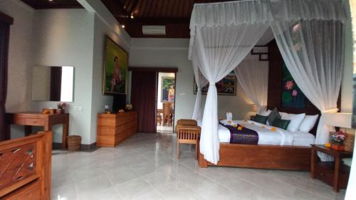a bedroom with a large bed with a canopy at Ubud Paradise Villa in Ubud