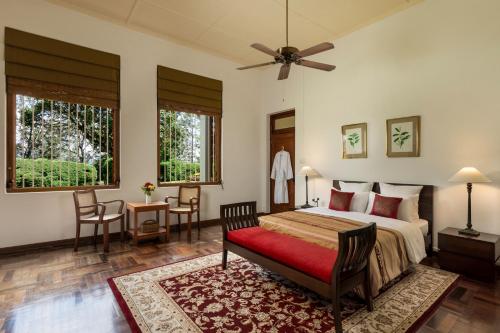 a bedroom with a bed and a table and chairs at Jetwing Uva Ben Head Villa in Welimada