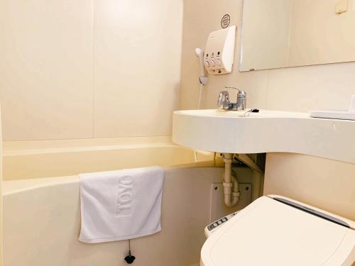 uma casa de banho branca com um lavatório e um WC em Toyoko-Inn Busan Jungang Station em Busan