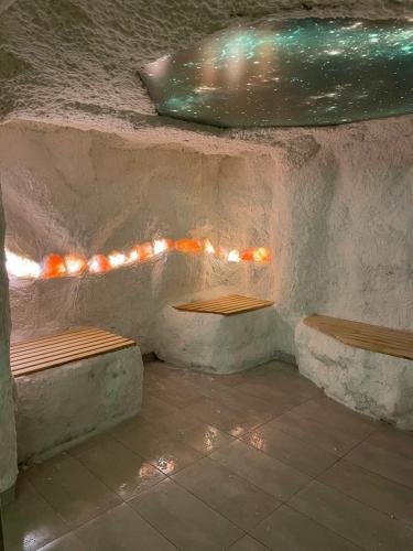 two benches sitting next to a wall with lights at Apartmani NLUX and SPA in Kopaonik