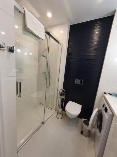 een badkamer met een glazen douche en een toilet bij Apartament Kołobrzeg in Kołobrzeg