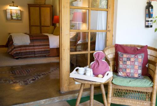 a room with a chair and a table with a mirror at York Lodge in Harare