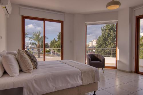 een slaapkamer met een bed en een groot raam bij Phaedrus Living: City Flat Palas 102 in Paphos City