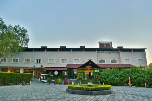 a large white building with a courtyard in front of it at Bamboo Saa Resort & Spa - Udaipur in Udaipur