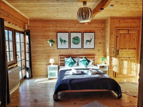 een slaapkamer met een bed in een houten kamer bij Pokoje i Domki Na Szlaku in Polanica-Zdrój