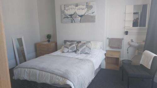 a small bedroom with a bed and a sink at Tudor Lodge - Redcar Beach in Redcar