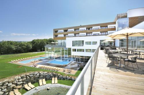 einen Balkon eines Gebäudes mit einem Tisch und einem Sonnenschirm in der Unterkunft Golf & Wellness Apartment 34. in Bad Waltersdorf