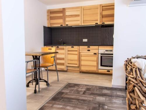 une cuisine avec des placards en bois et une table dans l'établissement Magnifique T2 avec balcon et animaux admis - FR-1-503-143, à Balaruc-les-Bains