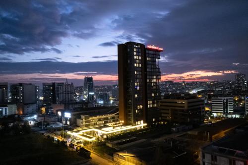 a city skyline at night with a tall building at Movenpick Living Istanbul West in Istanbul